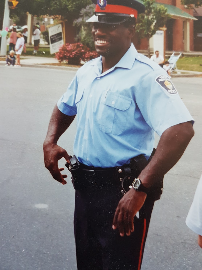 Keith Merith smiling in early patrol uniform during a community event
