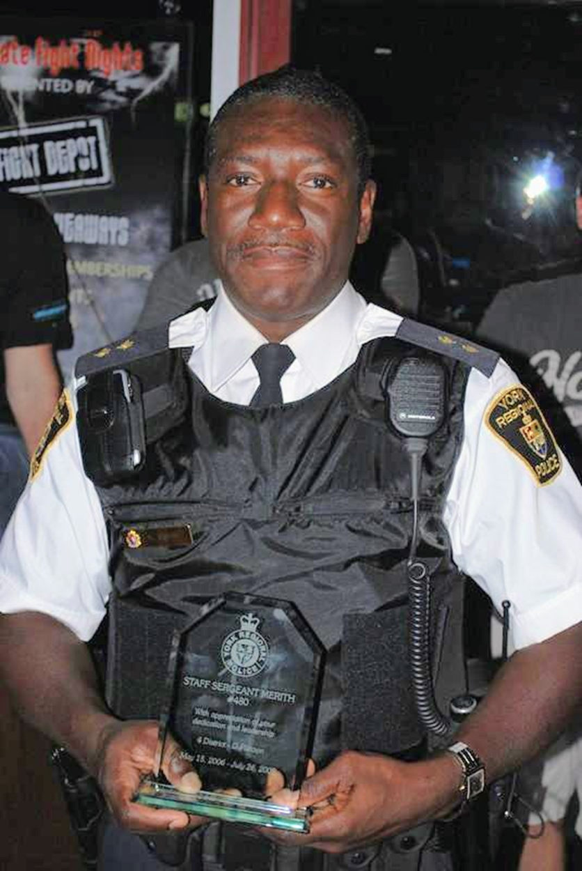 Staff Sergeant Merith holding a York Regional Police service award