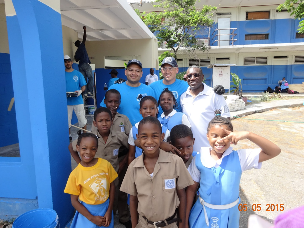 Keith Merith painting a school in Kingston, Jamaica with fellow officers and students
